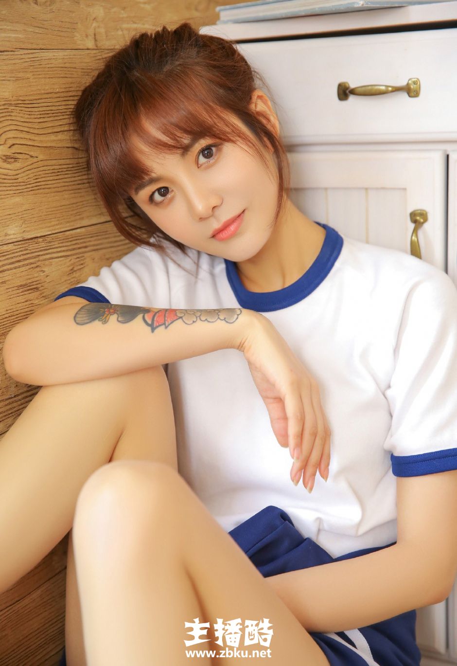 大长腿运动服短裤美女高束马尾辫双手托腮低头浅笑图片