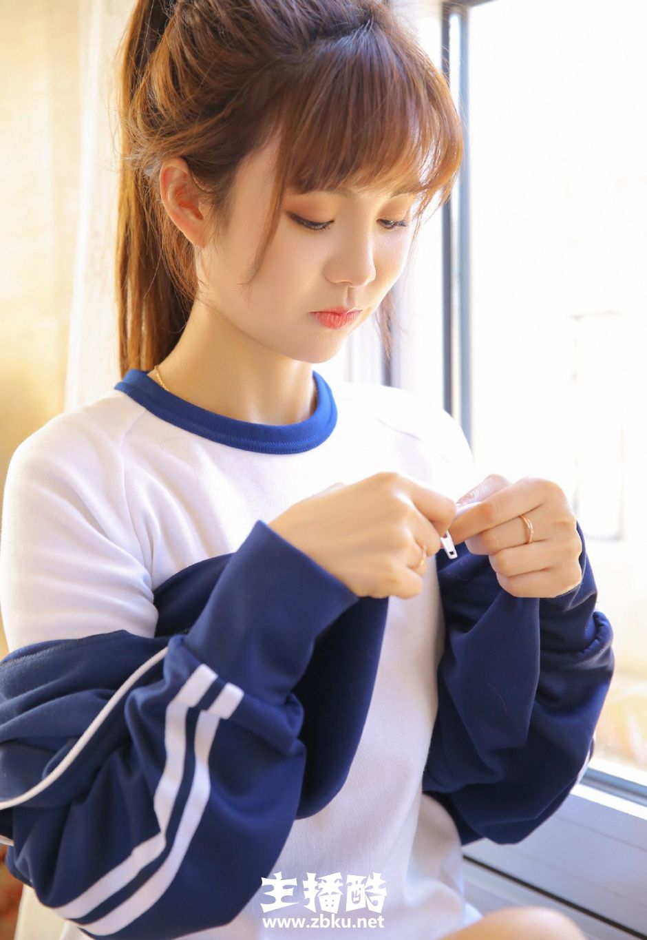 大长腿运动服短裤美女高束马尾辫双手托腮低头浅笑图片
