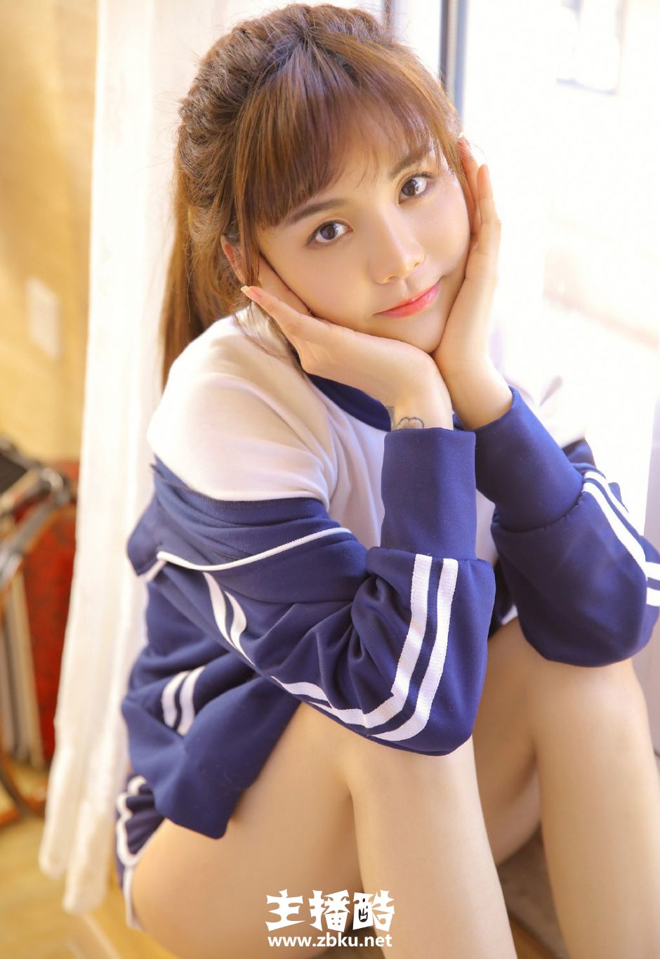 大长腿运动服短裤美女高束马尾辫双手托腮低头浅笑图片